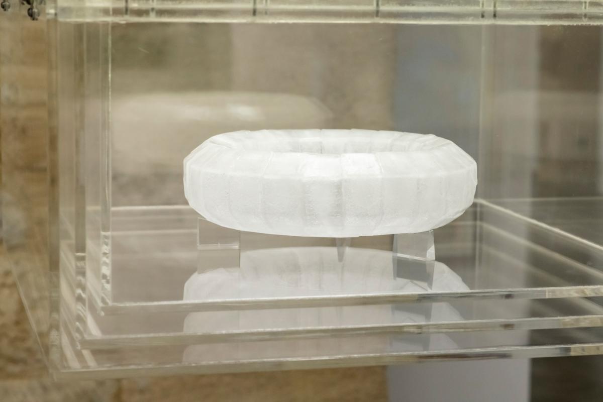 Un mazzocchio de glace est présenté dans un support transparent en plexiglas. 