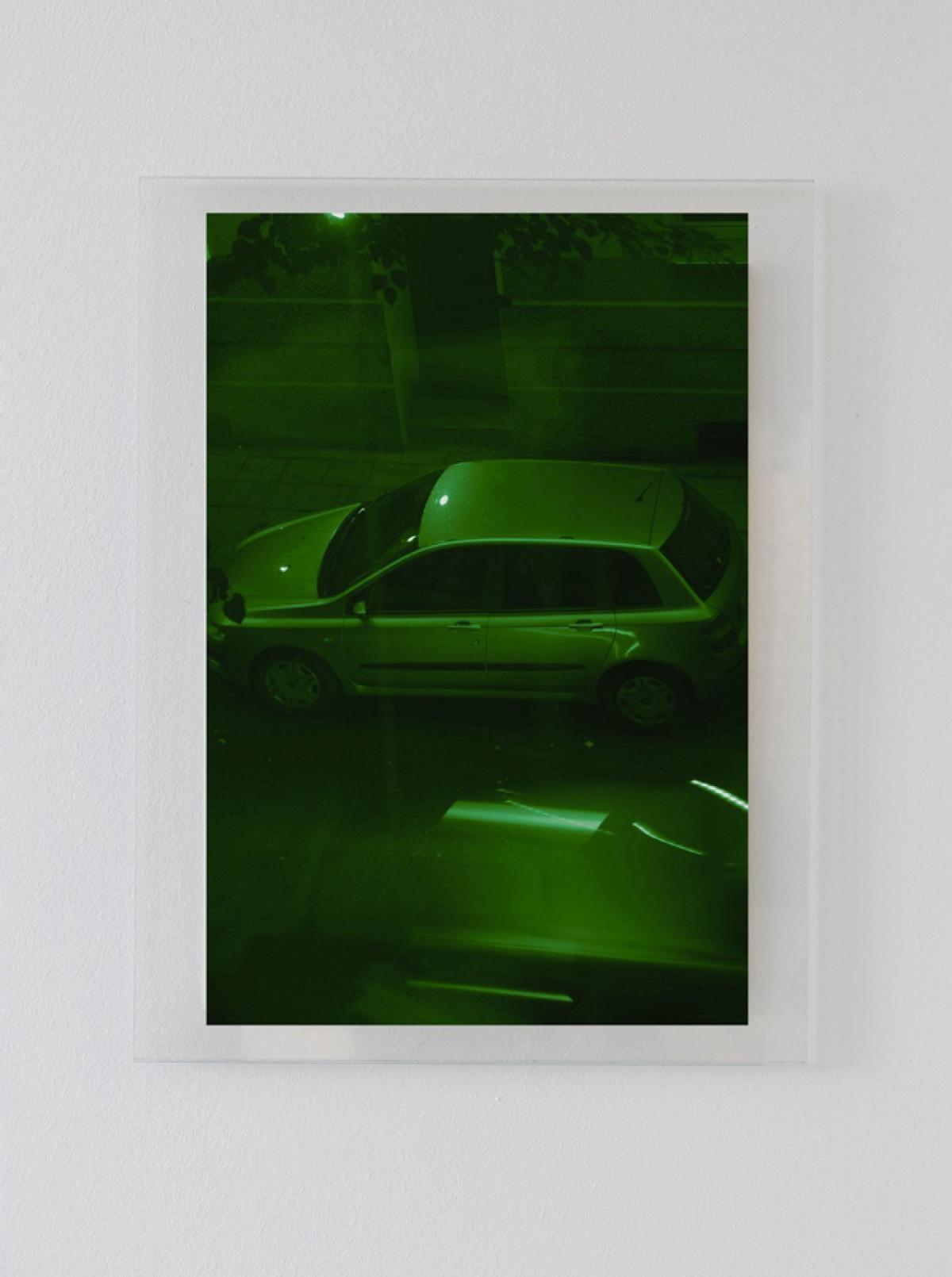 Photo de voiture prise depuis une fenêtre. L'image est teintée d'une couleur verte.